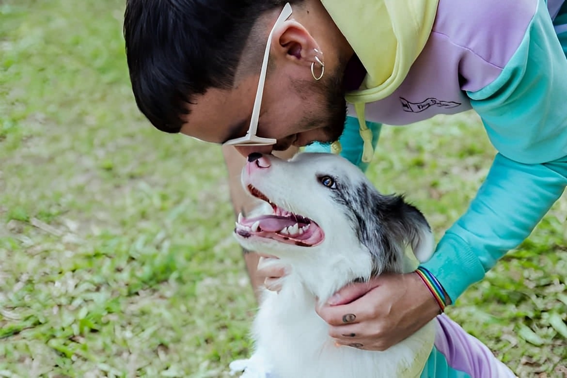 un hombre besa a su perro en la nariz