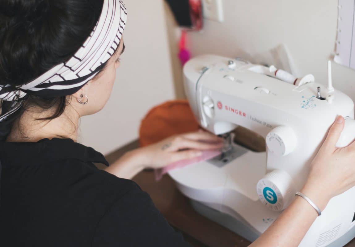 una mujer está usando una máquina de coser para coser