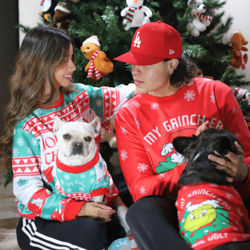 dos mujeres con feos suéteres navideños a juego con un perro